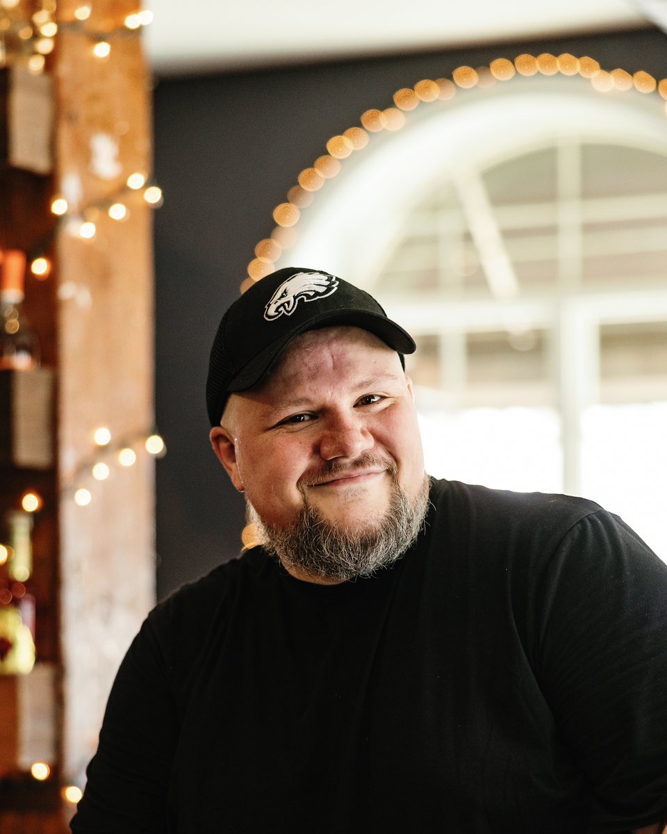 Justin Mabee, smiling, in a black cap and t-shirt